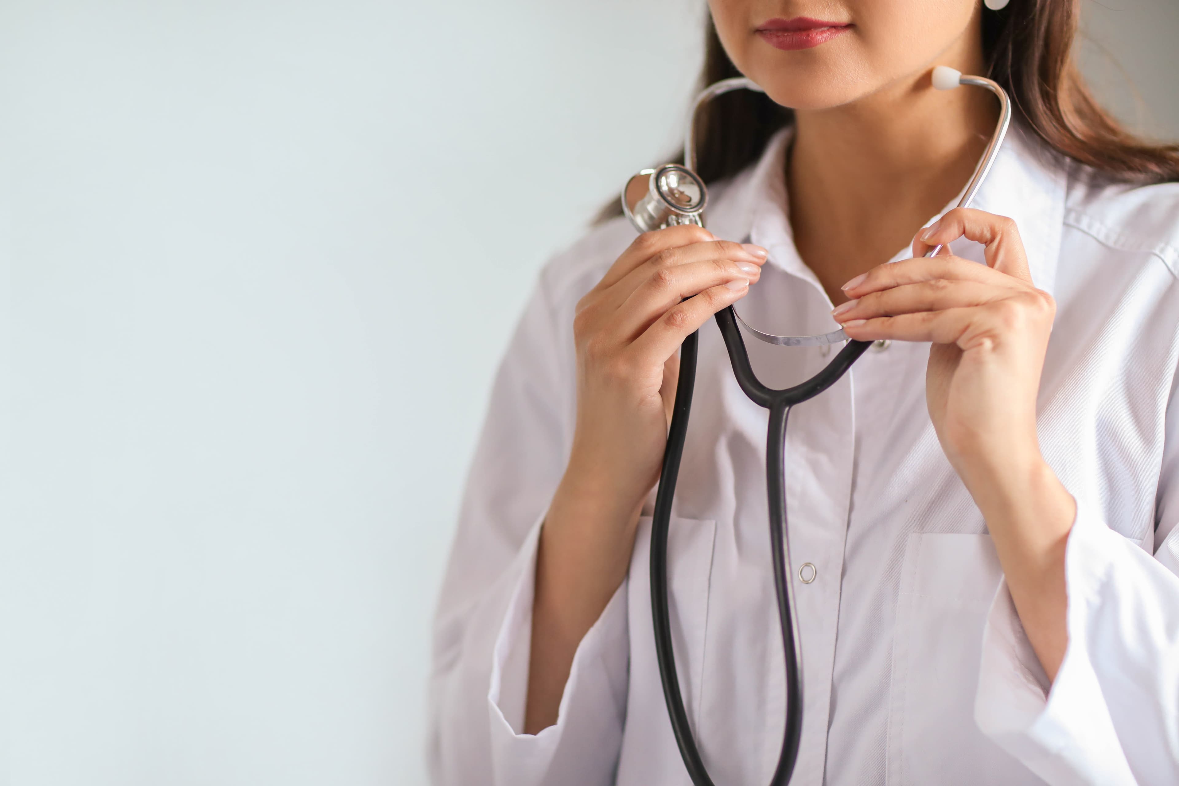A clinician holding a stethoscope, ready for the next patient
